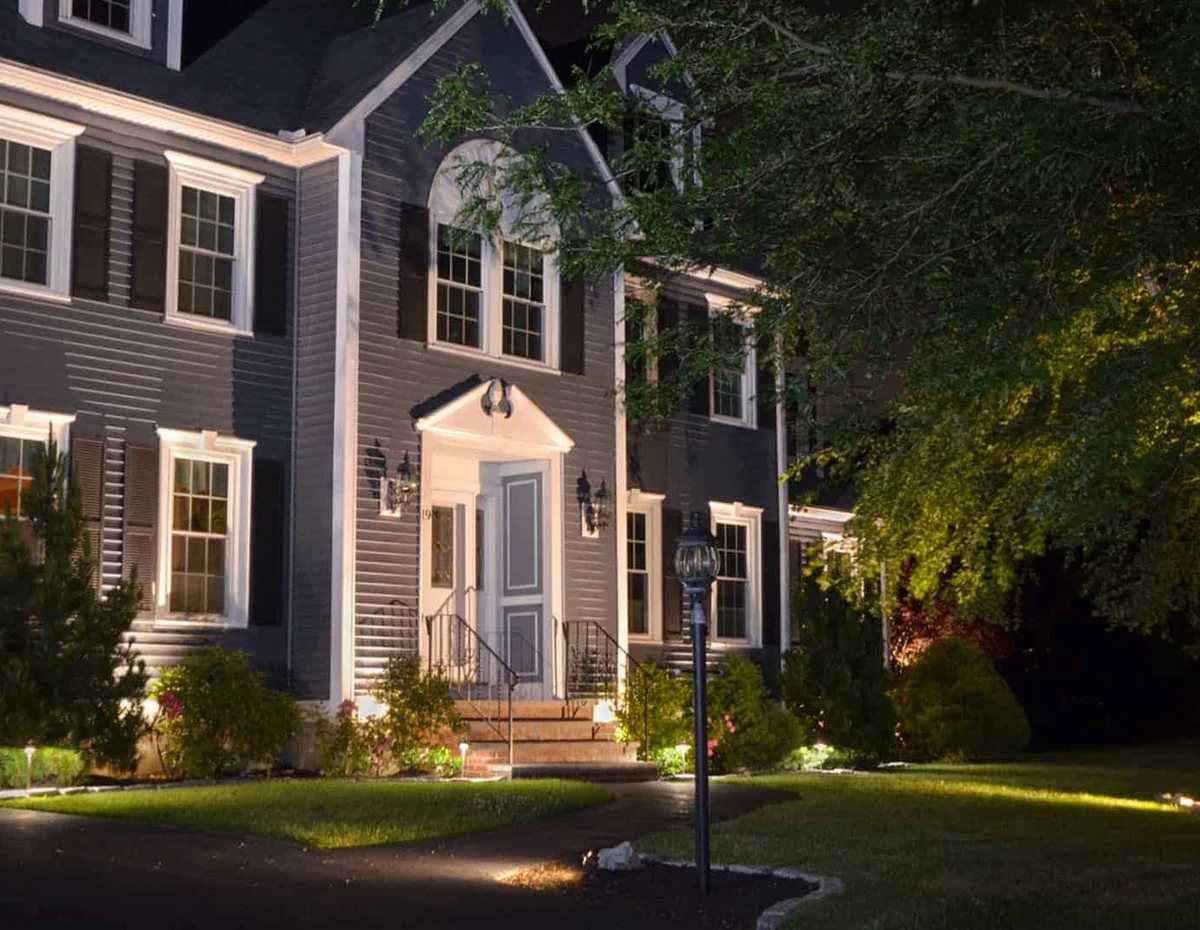Landscape lighting picking out a home and its trees after dark