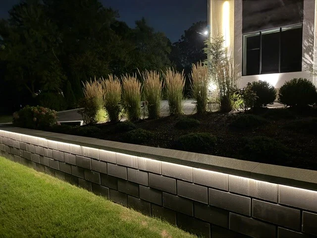 Integrated retaining wall lighting beside a residential lawn in Newton, MA.