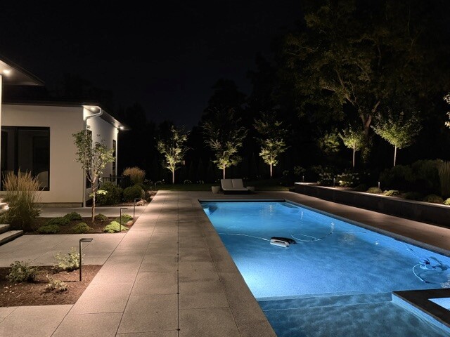 Low-voltage path lighting along a residential swimming pool in Newton, MA.